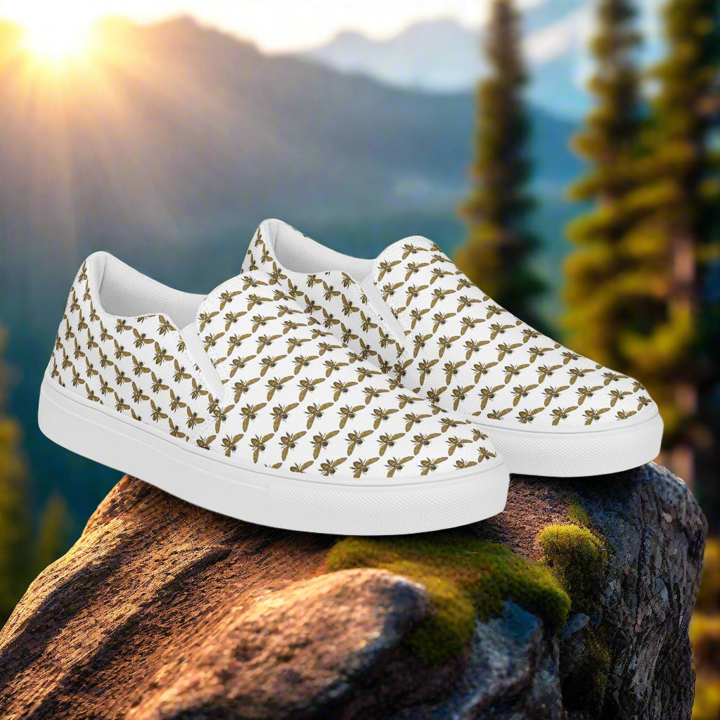 WildSage Market bee pattern slip on shoes with white sole displayed on a rock outdoors