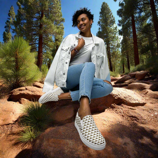 WildSage Market bee pattern slip on shoes worn by woman sitting on rocks in outdoor forest setting