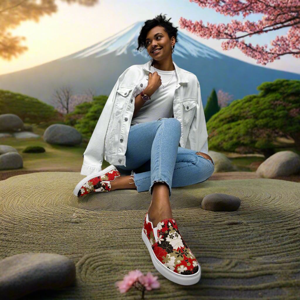 Black Lotus floral print womens slip on canvas shoes worn by woman sitting in zen garden with mountain background
