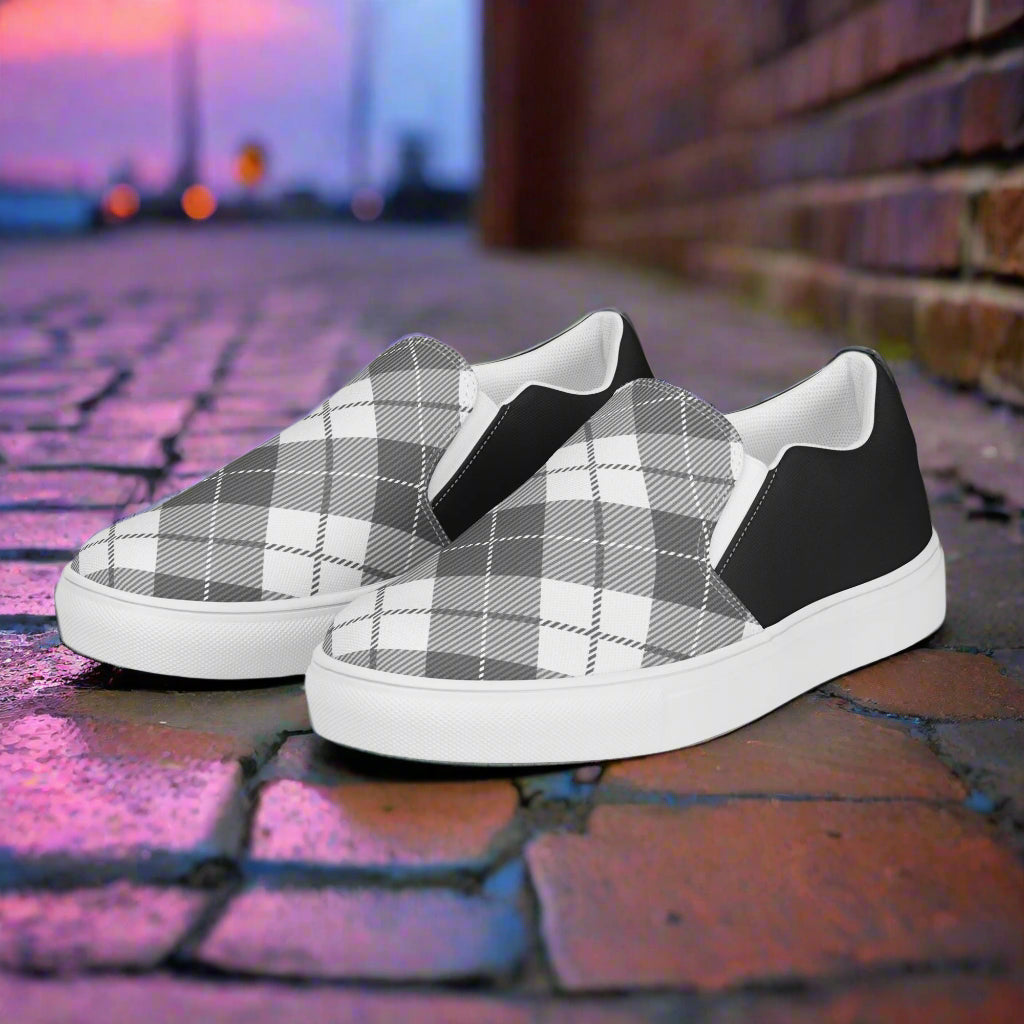 Black Plaid Halftone Slip-On Canvas Shoes by WildSage Market on a brick path at sunset