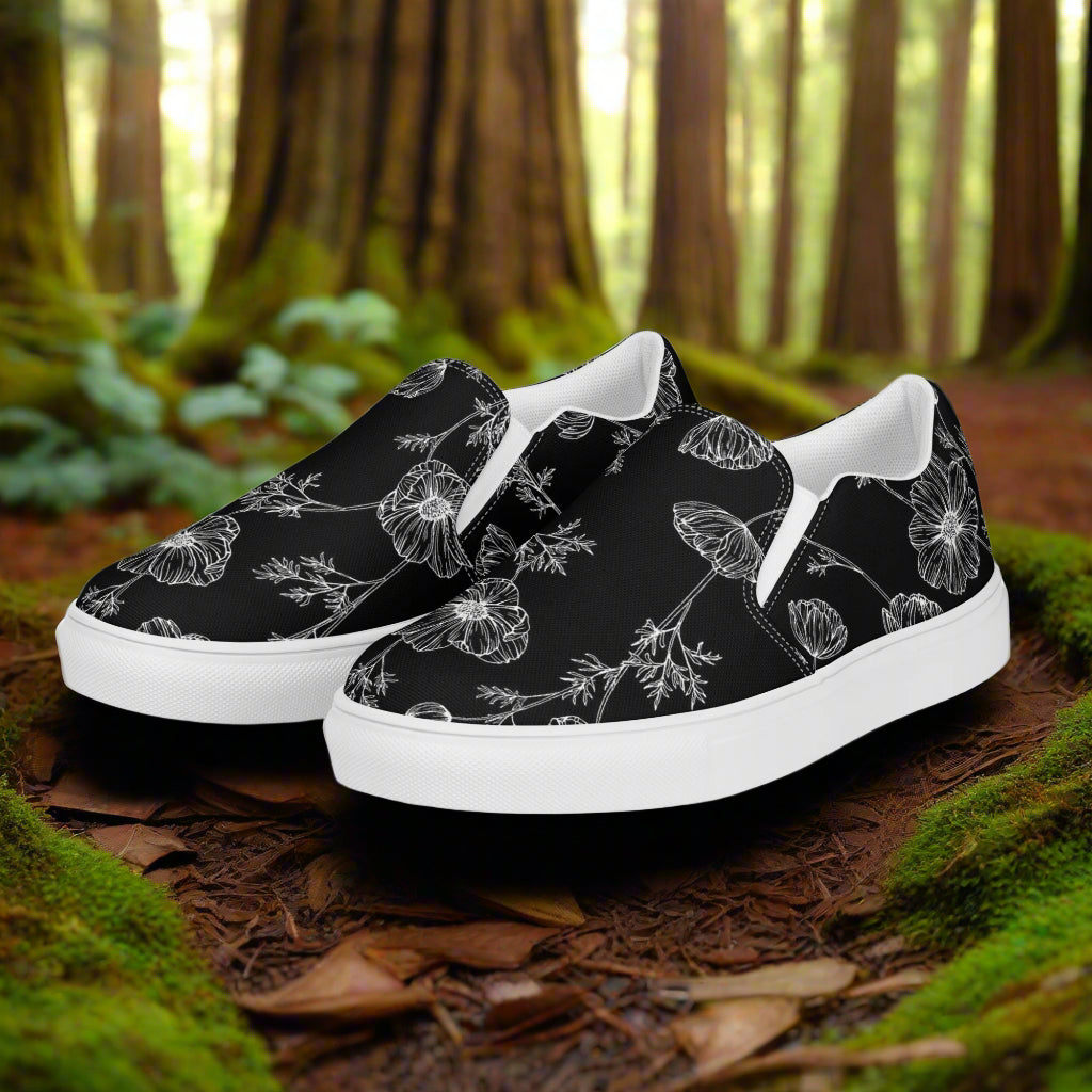 Black Poppy Slip-on Canvas Shoes featuring a floral design on a natural forest background
