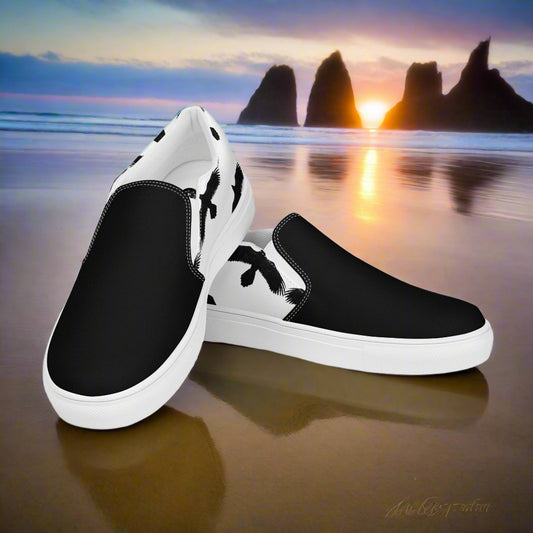 Black Ravens White Two Tone Slip-on Canvas Shoes displayed on a beach at sunset