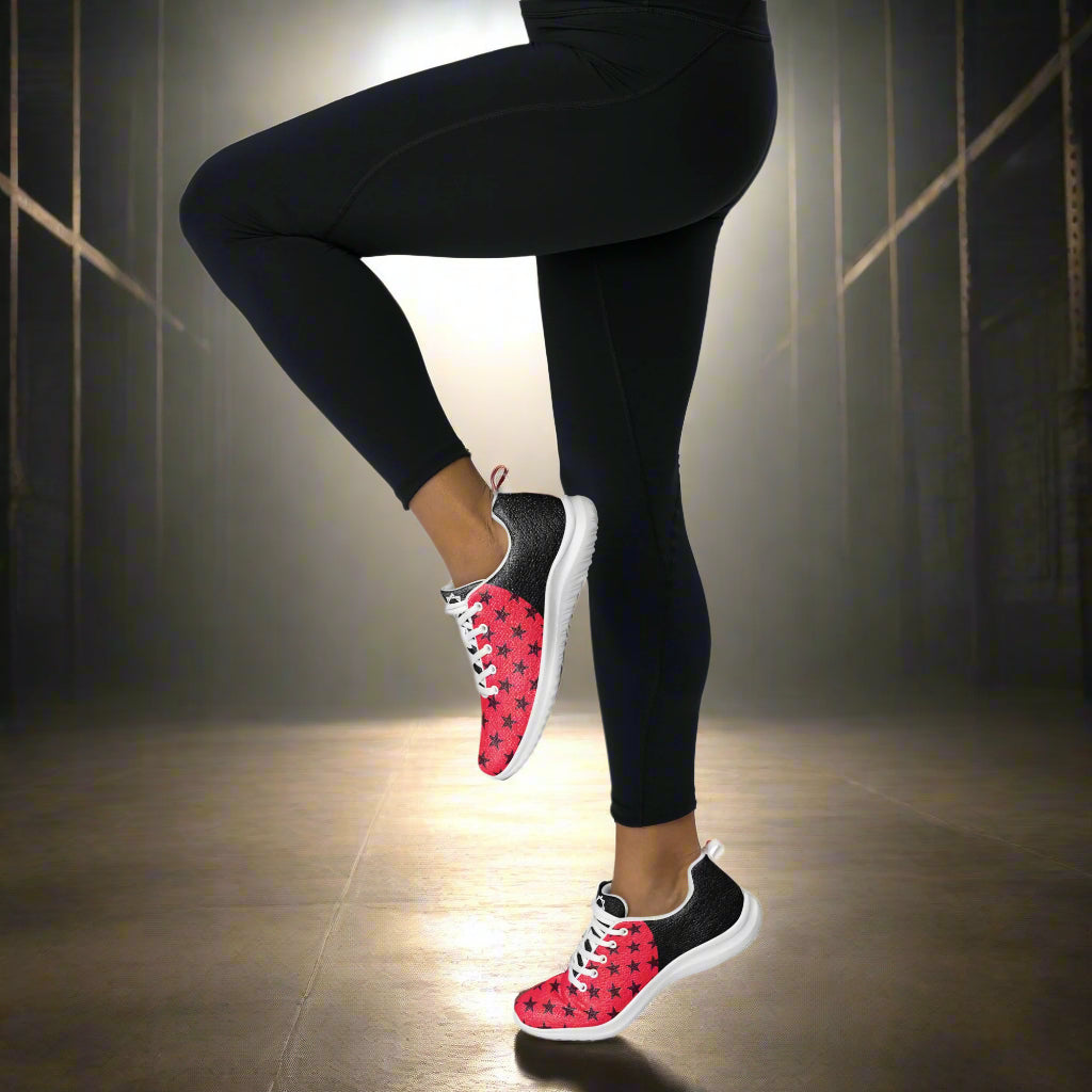 Black Stars Red Halftone Womens Athletic Shoes by WildSage Market worn with black leggings in a dimly lit room