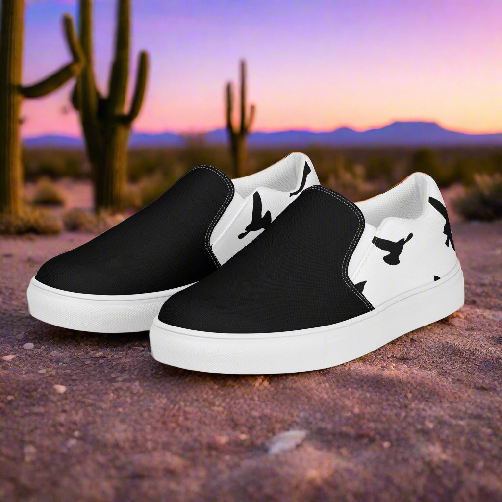 WildSage Market Slip-on Canvas Shoes black and white with bird silhouette heel on desert background