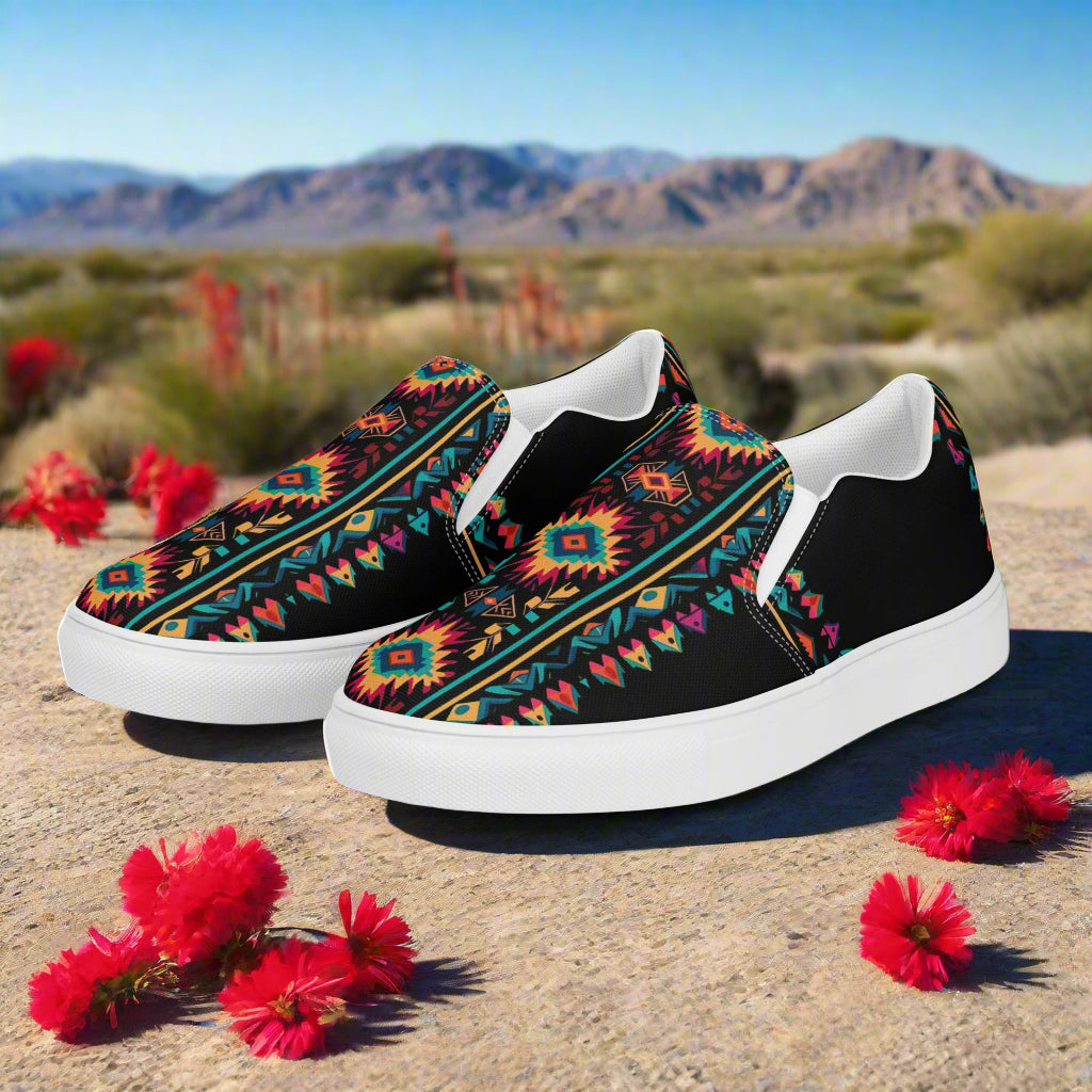 Ixtlan Southwest Print Slip-on Canvas Shoes with vibrant tribal design against a desert backdrop