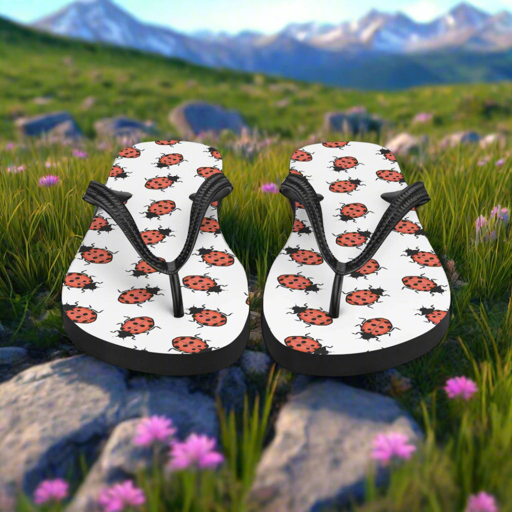 Ladybug print flip-flops with black straps, perfect for casual summer wear in the outdoors