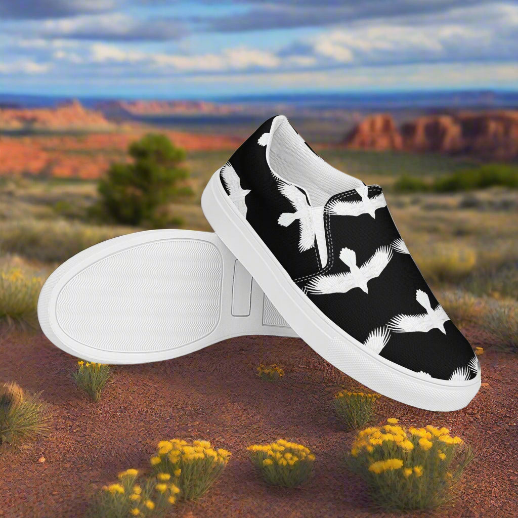 Mens white raven print slip on shoes by WildSage Market with black background and white bird design