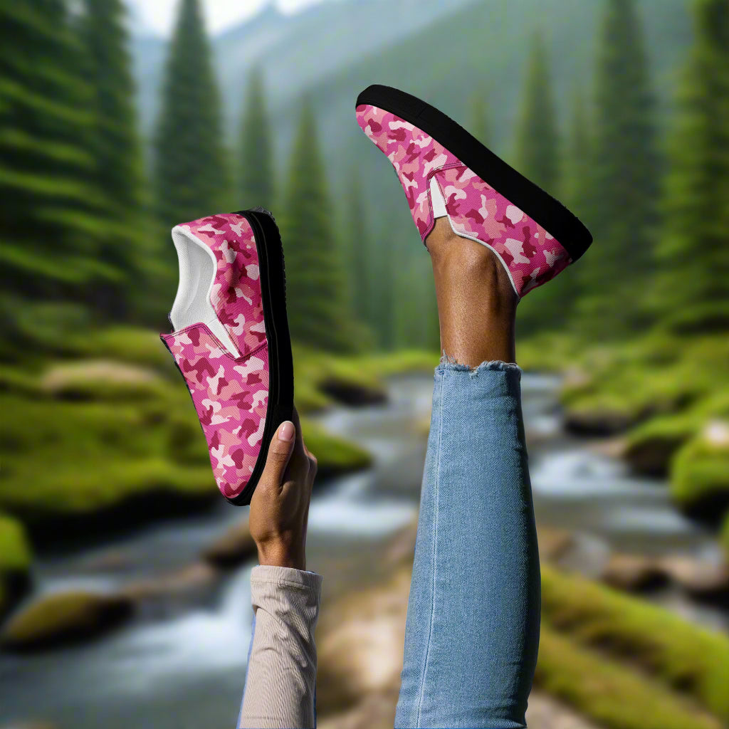 WildSage Market pink camo slip on shoes with black soles worn outdoors near a forest stream