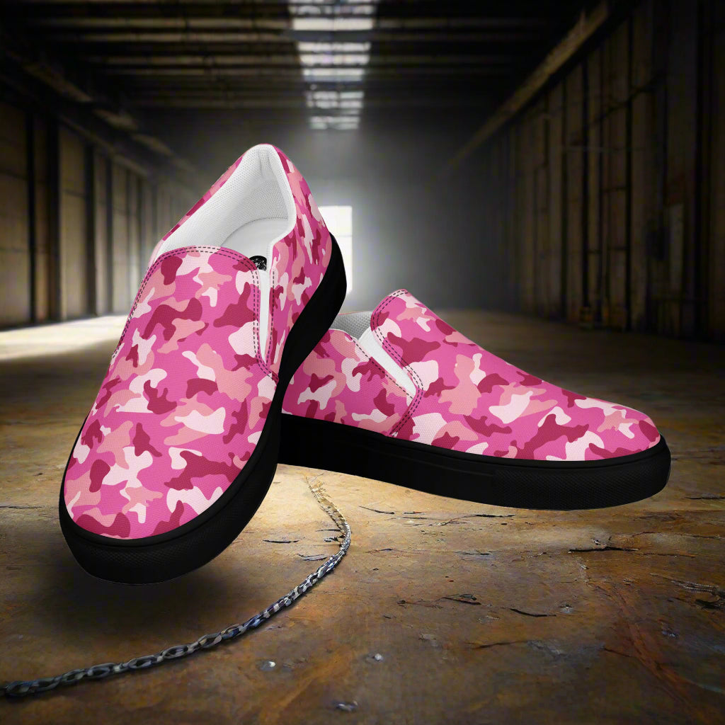 WildSage Market pink camo slip on shoes with black soles in an industrial background
