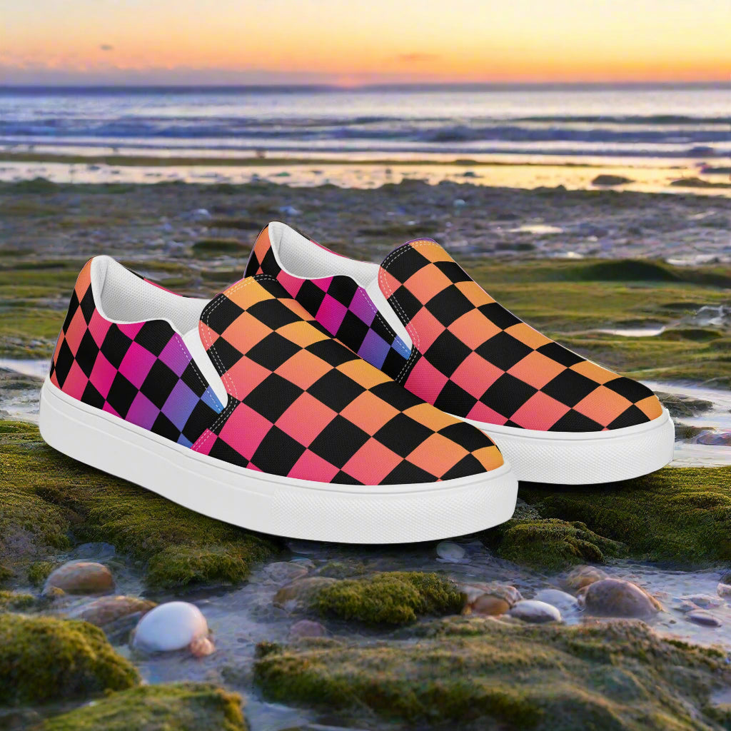 Rainbow Chex Slip-On Canvas Shoes featuring a vibrant checkerboard pattern on a beach background
