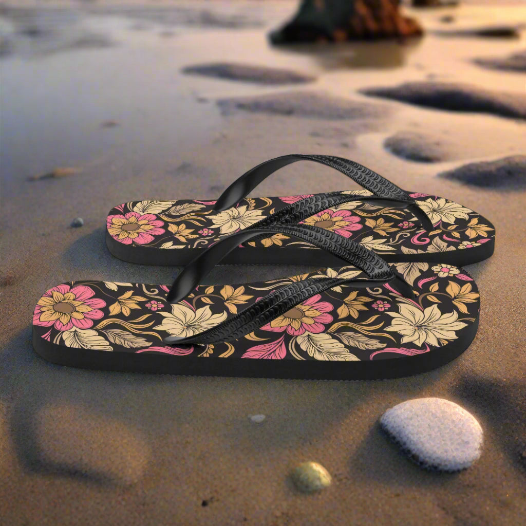 WildSage Market retro floral pattern flip-flops with black straps on sandy beach
