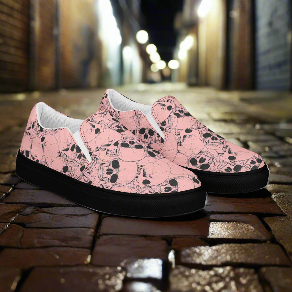 WildSage Market slip on shoes with pink skull pattern and black soles on a cobblestone street