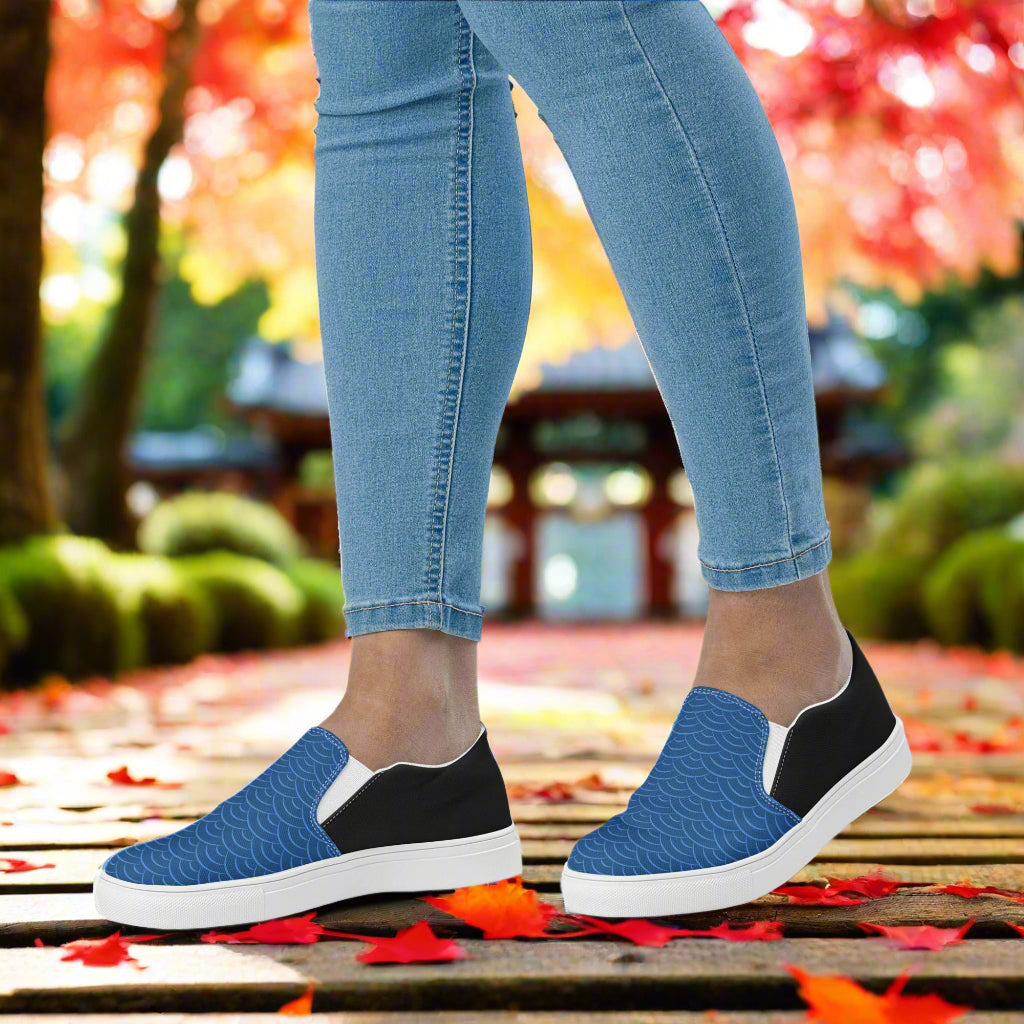 Slip-on Canvas Shoes Blue Seas Halftone in a stylish blue pattern worn on a person walking on a wooden path