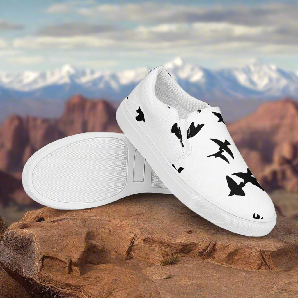 WildSage Market slip on shoes blackbirds pattern in white with black bird silhouettes on rocky mountain background