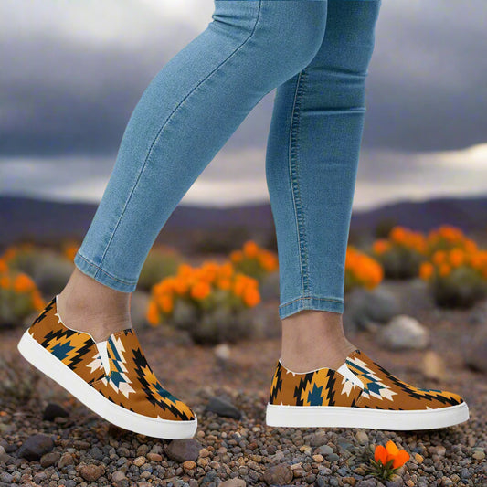 WildSage Market Southwest print slip on canvas shoes Pueblo worn with skinny jeans on rocky ground with orange desert flowers