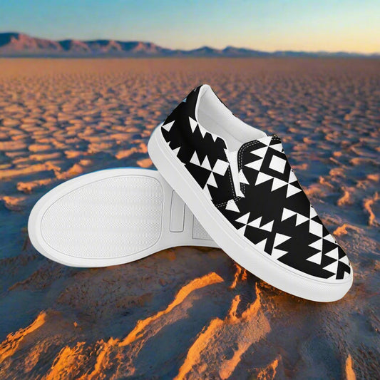 Southwest styled womens slip-on canvas shoes in black and white geometric design on desert background