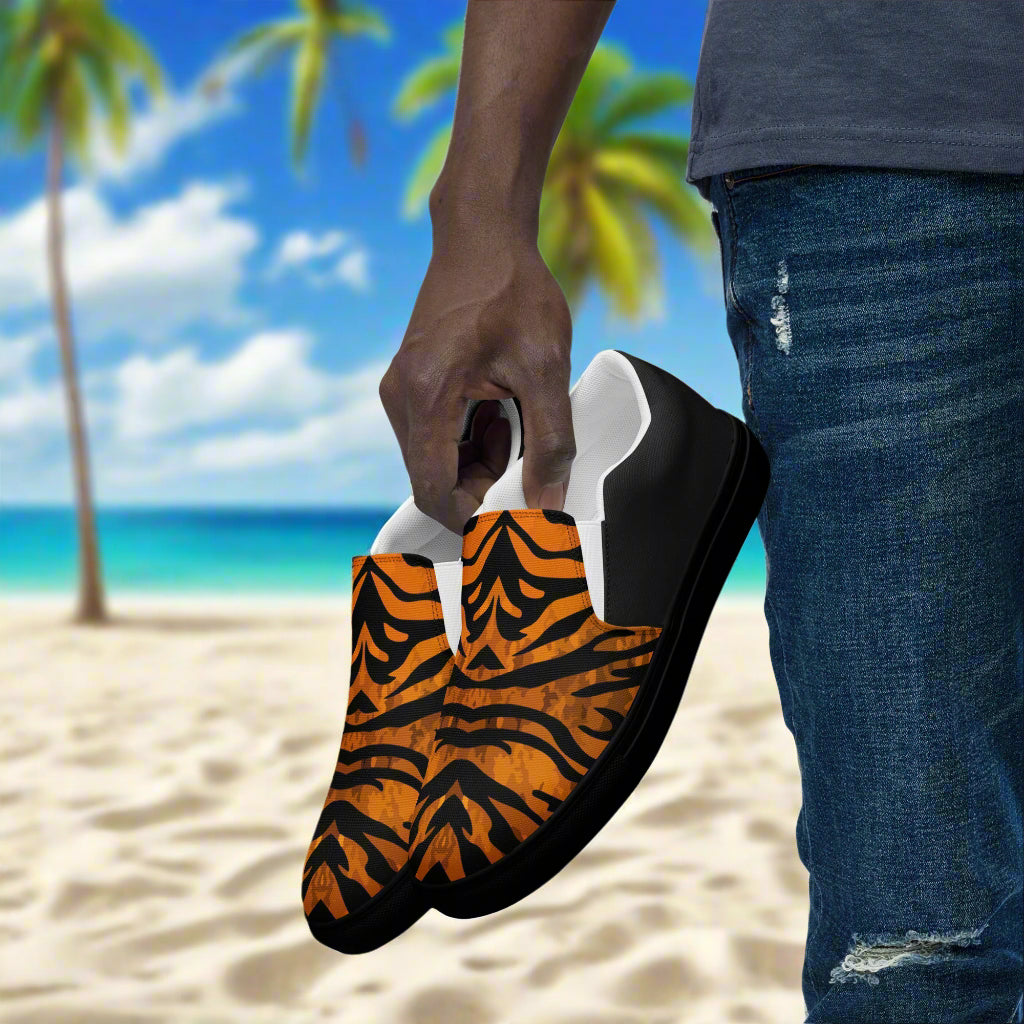 WildSage Market slip on shoes with tiger halftone pattern held by person on the beach