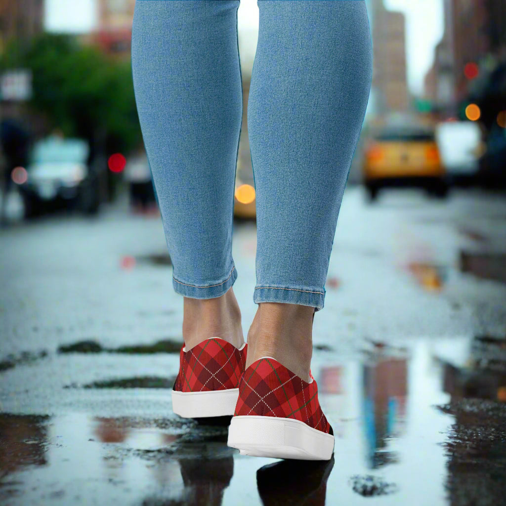 Plaid Red Slip-On Canvas Shoes by WildSage Market worn with ankle jeans on wet city street with puddle reflection