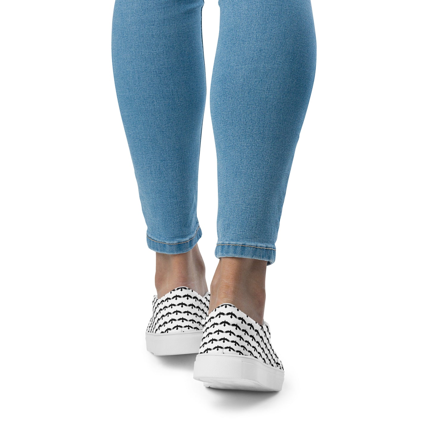 Close-up of black raven pattern slip on shoes worn with blue jeans from WildSage Market