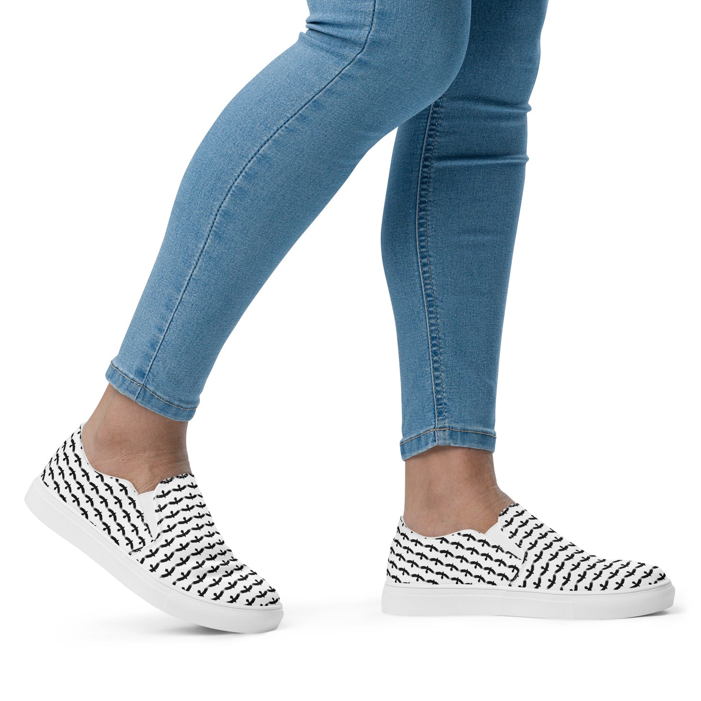 WildSage Market black raven pattern slip on shoes worn with blue jeans on a model