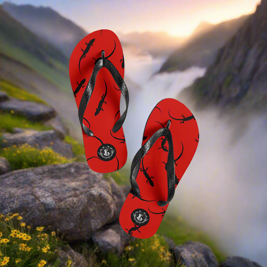 WildSage Market red lizard print flip flops with black straps on a scenic mountain background