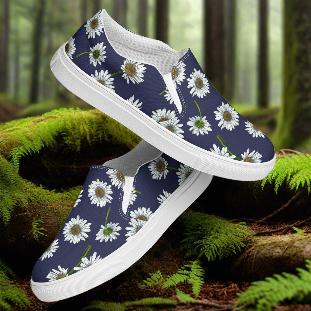 White Daisy Slip-on Canvas Shoes on a natural forest background with greenery and foliage