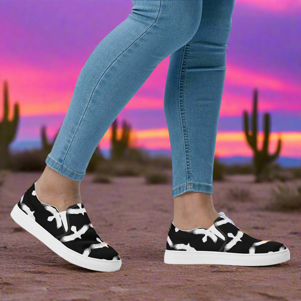 WildSage Market white Ravens slip on canvas shoes with a black and white pattern worn with jeans