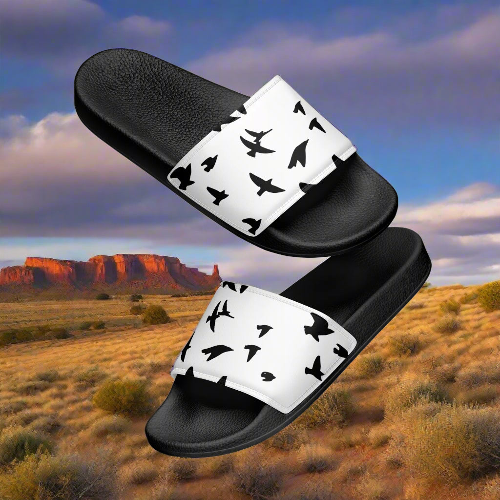 Womens blackbird print slides by WildSage Market with black soles and white straps featuring black bird silhouettes