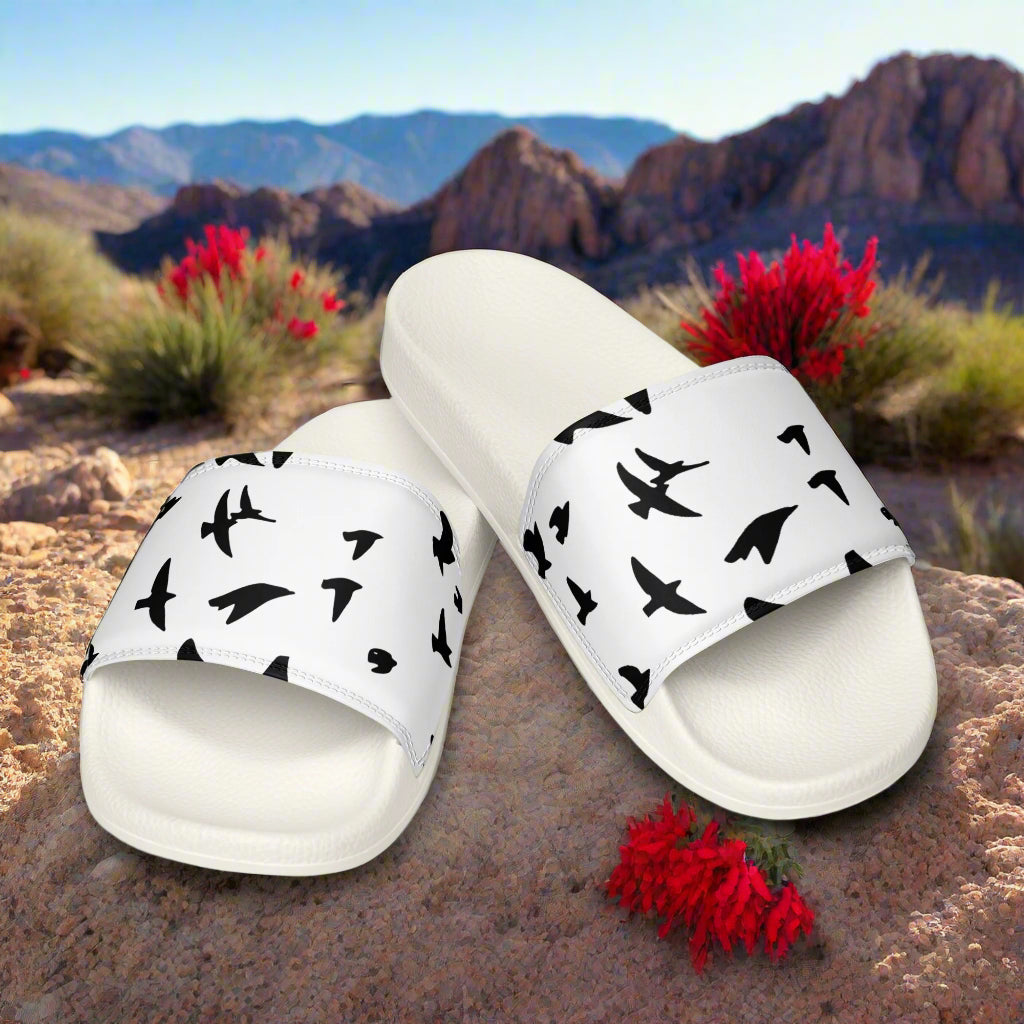 WildSage Market womens blackbird print slides with black bird silhouettes on white straps outdoors