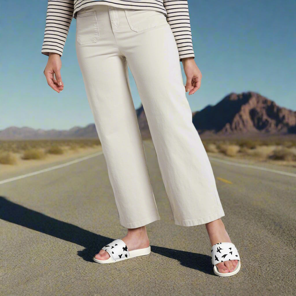 WildSage Market womens blackbird print slides worn with white pants on desert road