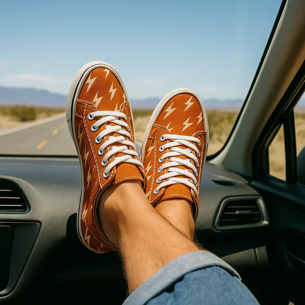 Stylish canvas shoes with lightning pattern worn during a road trip in a sunny landscape