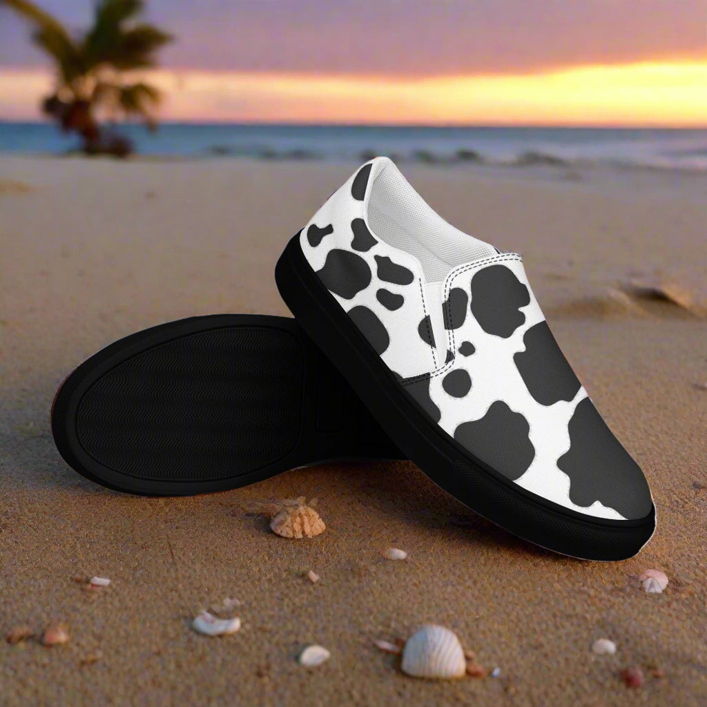 WildSage Cowhide Black Slip-on Canvas Shoes with a stylish cow print design, perfect for casual wear.