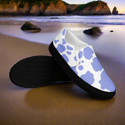 WildSage Cowhide Purple Slip-on Canvas Shoes with unique cow print design on a beach background