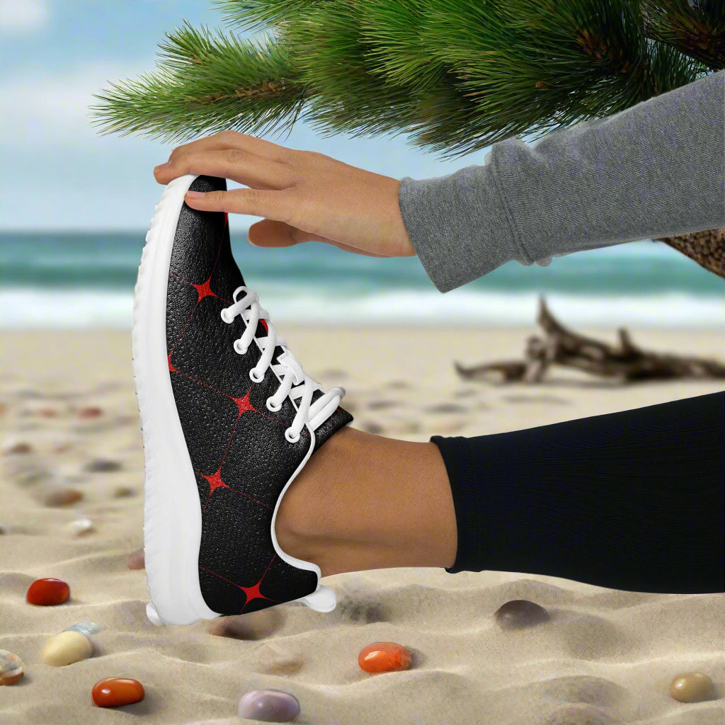 Stylish Women's Crimson Diamond Athletic Shoes worn on a beach with colorful pebbles