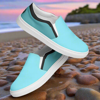 WildSage Market teal slip on canvas shoes with white soles on a rocky beach background