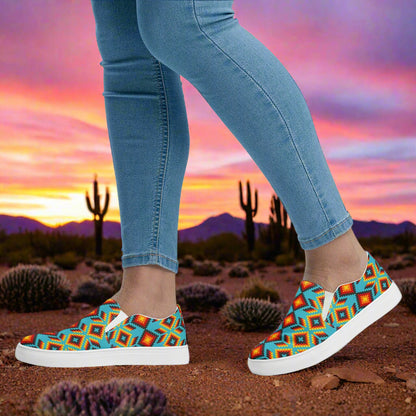 Huichol Southwest Print Slip-on Canvas Shoes worn with denim jeans against a vibrant sunset backdrop