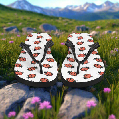 Ladybug print flip-flops with black straps, perfect for casual summer wear in the outdoors