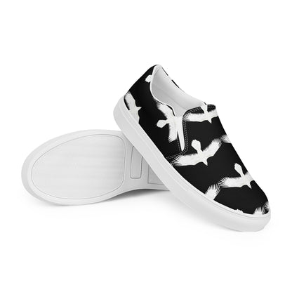 Mens white raven print slip on shoes by WildSage Market with black background and white bird design