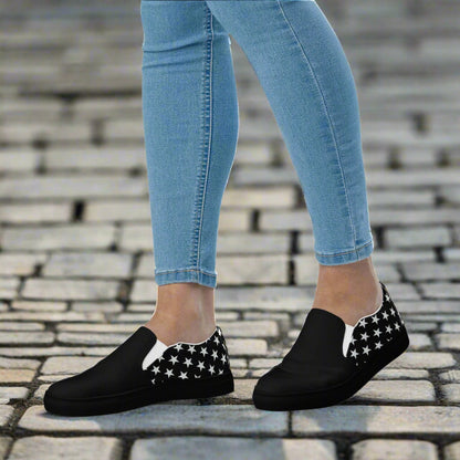 WildSage Market white star two tone slip on canvas shoes worn with light blue jeans on cobblestone pavement