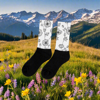 Womens White Floral Print Socks with Black Poppy Pattern displayed against a scenic mountain and flower background