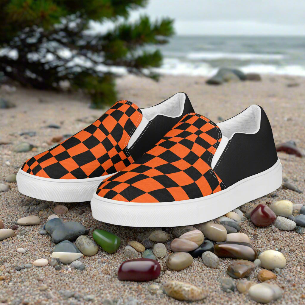 Wonderland Orange Chex Halftone Slip-On Canvas Shoes featuring a bold orange and black design on a beach setting