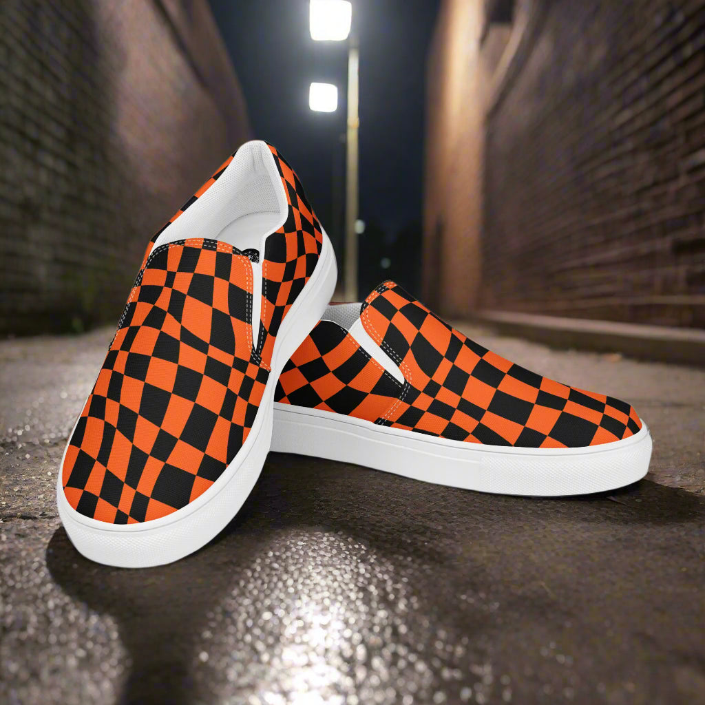 Wonderland Orange Chex Slip-On Canvas Shoes with a vibrant black and orange checkerboard pattern